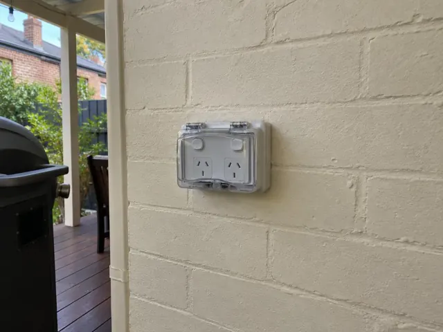 Outdoor double power point on a painted brick wall beside a patio in Balmain